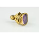A MID VICTORIAN AMETHYST SEAL, the grip with floral and foliate decoration set with a rectangular