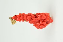 A DYED CARVED CORAL 9CT GOLD PENDANT of elongated outline, the coral carved to depict flowers and