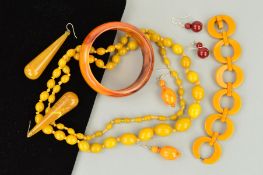 A SELECTION OF PLASTIC JEWELLERY to include a circular disc bracelet in dark yellow bakelite, a long