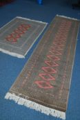 A 20TH CENTURY YOMUT CARPET RUNNER, red and green ground on a geometric design, 314cm x 81cm,