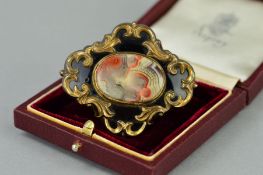 A LATE VICTIORIAN BROOCH, the gold plated brooch with replacement oval agate centre panel within a