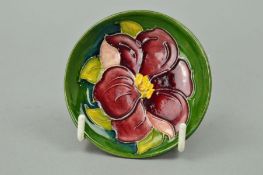 A SMALL MOORCROFT POTTERY TRINKET DISH, 'Clematis' pattern on green ground, impressed backstamp to
