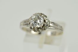 A LATE 20TH CENTURY 18CT GOLD DIAMOND CLUSTER RING, centering on a modern round brilliant cut