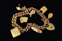 A 9CT GOLD CHARM BRACELET the graduated curb link bracelet suspending seven charms to include a