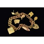 A 9CT GOLD CHARM BRACELET the graduated curb link bracelet suspending seven charms to include a