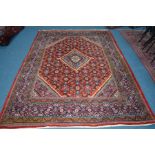 A 20TH CENTURY KUBA STYLE RUG, red and blue ground of a geometric design, 303cm x 207cm