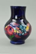 A SMALL MOORCROFT POTTERY VASE, 'Orchid' pattern on blue ground, impressed and painted blue marks to