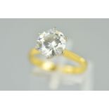 AN 18CT GOLD MOISSANITE SINGLE STONE RING, the circular moissanite within a six claw setting,