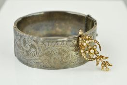 A BROOCH AND A BANGLE to include an early 20th Century gold seed pearl brooch designed as a crescent