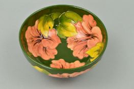 A MOORCROFT POTTERY FOOTED BOWL, 'Hibiscus' pattern inside and out on green ground, impressed