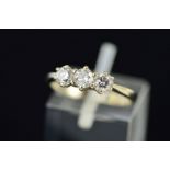 AN 18CT WHITE GOLD THREE STONE DIAMOND RING designed as three brilliant cut diamonds within claw