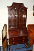 AN EDWARDIAN MAHOGANY BUREAU BOOKCASE, the canted top above double astragal glazed doors, fall front