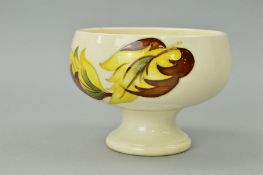 A SMALL MOORCROFT POTTERY FOOTED BOWL, 'Leaves in the Wind' pattern on cream ground, impressed and