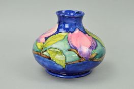 A MOORCROFT POTTERY SQUAT VASE, 'Magnolia' pattern on a blue ground, impressed marks and painted