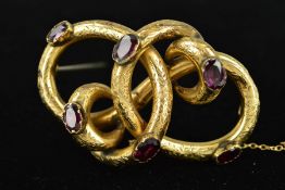 A MID VICTORIAN GOLD GARNET BROOCH of interlocking knot design set engraved with floral decoration