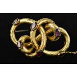 A MID VICTORIAN GOLD GARNET BROOCH of interlocking knot design set engraved with floral decoration