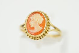 A 9CT CAMEO RING, the oval cameo depicting a lady in profile within a beaded surround with 9ct