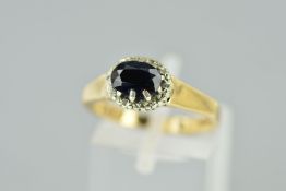 A 9CT GOLD SAPPHIRE AND DIAMOND RING, the central oval sapphire within a single cut diamond surround