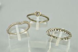 THREE PANDORA RINGS to include a v-shaped half eternity ring, a heart shape colourless gem with