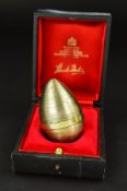 STUART DEVLIN, a cased Elizabeth II silver gilt surprise egg, the textured egg containing a silver