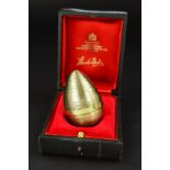 STUART DEVLIN, a cased Elizabeth II silver gilt surprise egg, the textured egg containing a silver