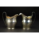 TWO GEORGE III SILVER BATEMAN CREAM JUGS, of helmet form, both with strap handles, one plain with