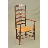 AN EARLY 19TH CENTURY ASH AND ELM RUSH SEATED ELBOW CHAIR, ladder back, turned stretchers and pad