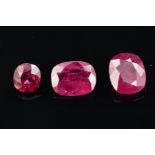 THREE RUBIES, first cushion cut, approximate weight 2.40ct, second cushion cut, approximate weight