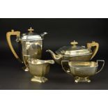 A GEORGE V SILVER FOUR PIECE TEA SERVICE, of rectangular form, cast flower head border, teapot and