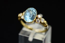 A LATE 20TH CENTURY 14CT GOLD AQUAMARINE AND DIAMOND DRESS RING, centring on an oval mixed cut