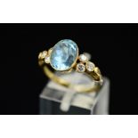 A LATE 20TH CENTURY 14CT GOLD AQUAMARINE AND DIAMOND DRESS RING, centring on an oval mixed cut