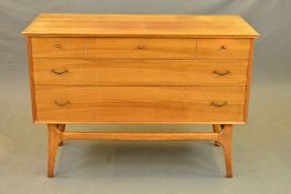 AN ALFRED COX WALNUT CHEST OF THREE LONG GRADUATING DRAWERS, on a teak stretchered base, width 109cm