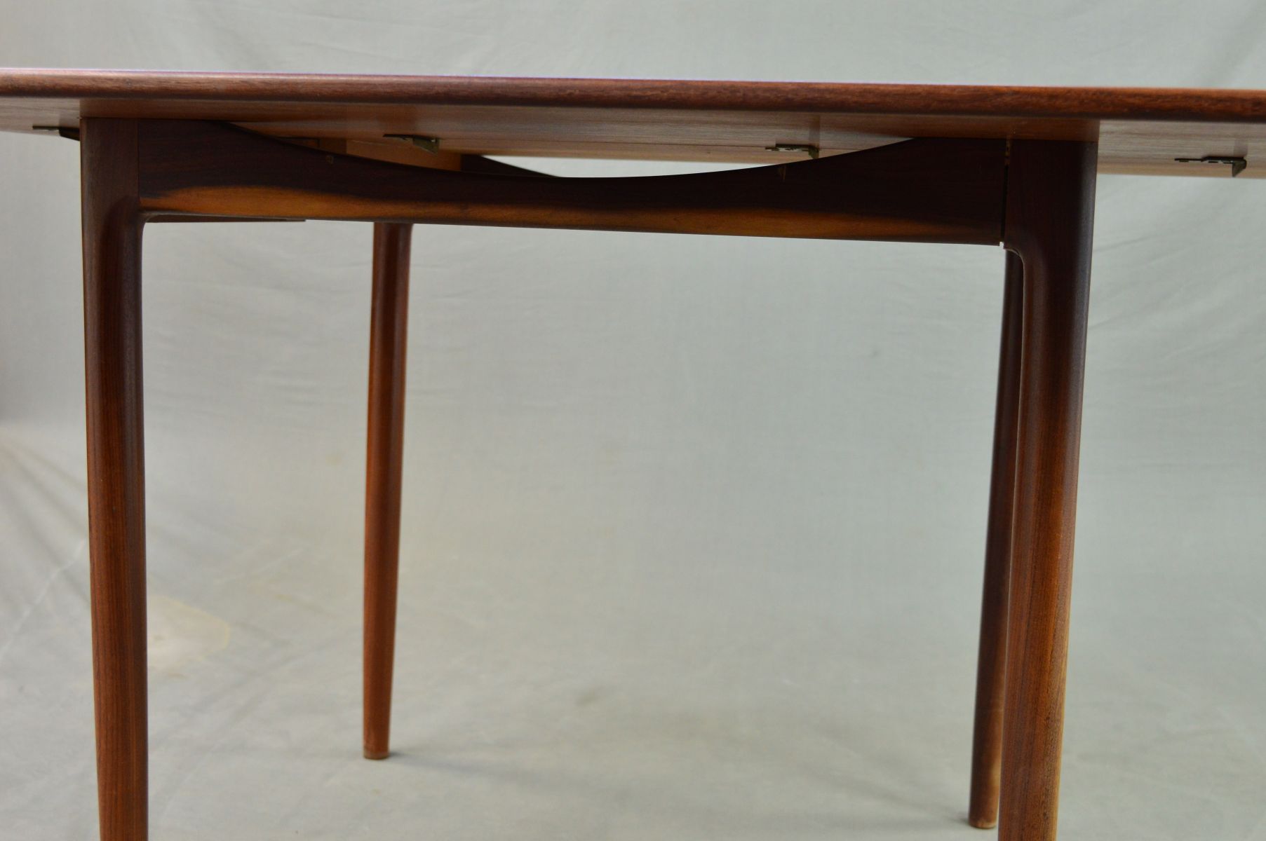 IB KOFOD LARSEN FOR G PLAN, a rectangular teak gate leg table on four cylindrical tapering legs, - Image 4 of 11