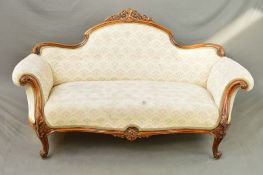 A VICTORIAN WALNUT FRAMED SOFA, the serpentine back with central carved and pierced foliate scroll