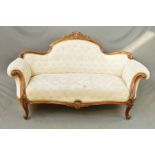 A VICTORIAN WALNUT FRAMED SOFA, the serpentine back with central carved and pierced foliate scroll