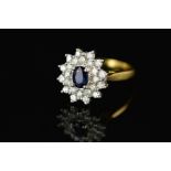 A MODERN SAPPHIRE AND DIAMOND OVAL CLUSTER RING, centring an oval mixed cut dark sapphire