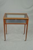 AN EDWARDIAN MAHOGANY AND BRASS BANDED GLASS TABLE TOP DISPLAY CASE, on four square graduating