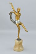 AN ART DECO SPELTER FIGURE OF A DANCER DISROBING, having a gold and silver patina, mounted atop an