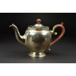 A GEORGE V SILVER TEAPOT, of bulbous form, decorative brown bakelite finial and 'S' scroll handle,