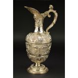 A VICTORIAN SILVER CELLINI PATTERN CLARET JUG, chased and embossed with masks and animals, the