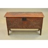 AN 18TH CENTURY OAK COFFER, the single plank top with chip carved ends, the front carved with