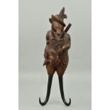 A 19TH CENTURY BLACK FOREST CARVED FOX MUSICAL COAT HOOK, modelled as wearing feathers in his hat,