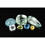 AN ASSORTMENT OF COLOURED BERYL GEMSTONES, to include yellow, green, white and dark blue aquamarine,