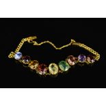 A MID 20TH CENTURY MULTI GEMSTONE GOLD BRACELET, oval mixed cut gemstones graduating in size from