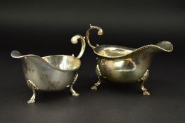 AN ELIZABETH II SILVER SAUCEBOAT, gadrooned rim, foliate cast 'S' scroll handle, on three cabriole