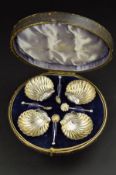 A LATE VICTORIAN CIRCULAR CASED SET OF FOUR SILVER SHELL SHAPED SALTS AND SPOONS, the salts on three