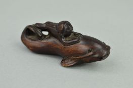 A MEIJI PERIOD CARVED WOODEN NETSUKE, in the form of a fish surmounted by a monkey, both with