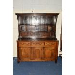 A GEORGE III AND LATER OAK DRESSER, the enclosed back with moulded cornice above two shelves, the