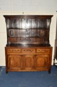 A GEORGE III AND LATER OAK DRESSER, the enclosed back with moulded cornice above two shelves, the