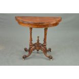 A VICTORIAN BURR WALNUT DEMI LUNE FOLD OVER CARD TABLE, revealing a green baize interior, on four